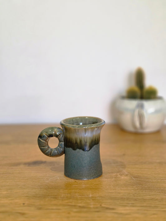 Anal thumb coffee cup, side, the handle to the left